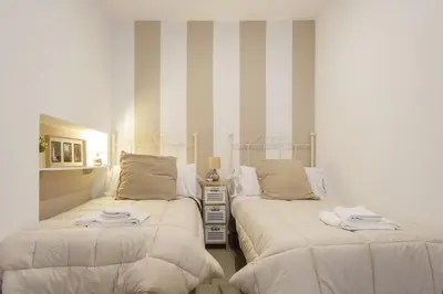 two beds in a room with striped walls at Catedral VIEW Apartment by Cadiz4Rentals in Cádiz