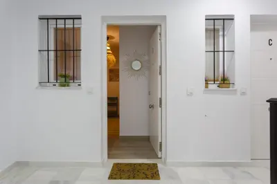 a hallway with white walls and a door with a mirror at Catedral VIEW Apartment by Cadiz4Rentals in Cádiz