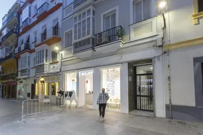 a man walking down a street in front of a store at Catedral VIEW Apartment by Cadiz4Rentals in Cádiz