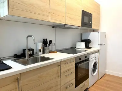 a kitchen with a sink and a dishwasher at El Aljibe de Botica in Cádiz