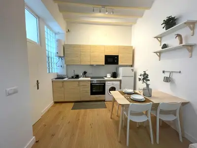 a kitchen with a wooden table and a table and chairs at El Aljibe de Botica in Cádiz