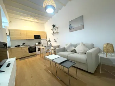 a living room with a couch and a kitchen at El Aljibe de Botica in Cádiz