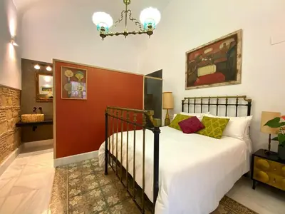 a bedroom with a bed and a chandelier at Casa Palacio Ánima in Jerez de la Frontera