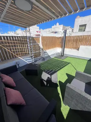 a patio with a couch and a table and grass at GATU PREMIUM Villa Galeona, con terraza privada chillout in Cádiz
