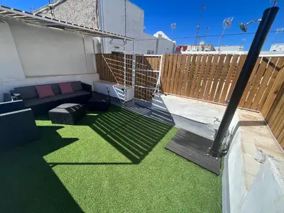 a small patio with green grass on a balcony at GATU PREMIUM Villa Galeona, con terraza privada chillout in Cádiz