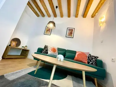 a living room with a green couch and a table at GATU PREMIUM Villa Galeona, con terraza privada chillout in Cádiz
