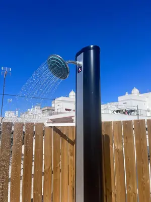 a black pole with a shower in front of a fence at GATU PREMIUM Villa Galeona, con terraza privada chillout in Cádiz