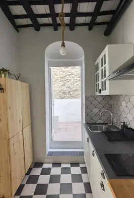 a kitchen with a black and white checkered floor at Casa del Sacramento - CASITA CON ENCANTO in Medina Sidonia