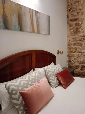 a bedroom with a bed with pillows on it at Casa del Sacramento - CASITA CON ENCANTO in Medina Sidonia