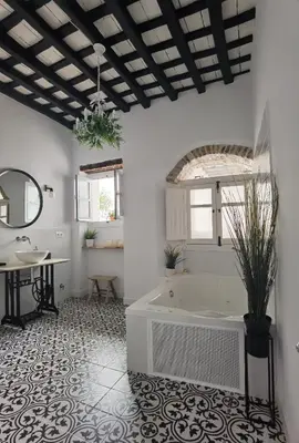 a bathroom with a tub and a table and a sink at Casa del Sacramento - CASITA CON ENCANTO in Medina Sidonia