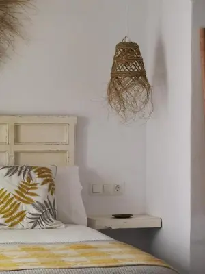 a bedroom with a bed and a hanging lamp at Casa del Sacramento - CASITA CON ENCANTO in Medina Sidonia