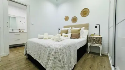 a white bedroom with a large bed with white sheets at Casa Populi entre Catedral y Ayuntamiento in Cádiz