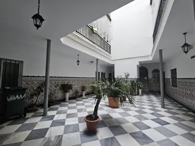 a room with potted plants on a checkered floor at Casa Populi entre Catedral y Ayuntamiento in Cádiz