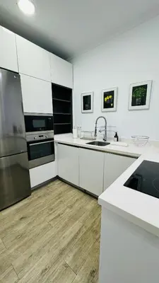 a kitchen with white cabinets and a stainless steel refrigerator at Casa Populi entre Catedral y Ayuntamiento in Cádiz