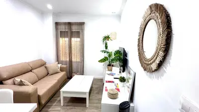 a living room with a couch and a mirror at Casa Populi entre Catedral y Ayuntamiento in Cádiz