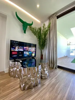 a living room with a tv and a dinosaur on the wall at VISTA LAGO VILLE in Chiclana de la Frontera
