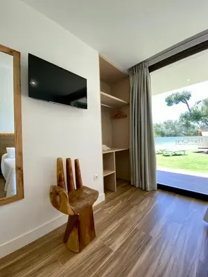 a living room with a chair and a television at VISTA LAGO VILLE in Chiclana de la Frontera