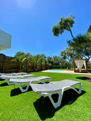 a row of white tables sitting on the grass at VISTA LAGO VILLE in Chiclana de la Frontera