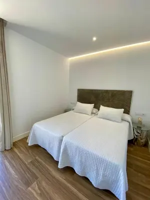 a bedroom with two beds with white sheets at VISTA LAGO VILLE in Chiclana de la Frontera