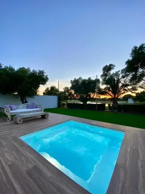 a large blue swimming pool on a wooden deck at VISTA LAGO VILLE in Chiclana de la Frontera
