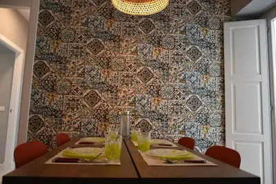 a dining room with a table and a patterned wall at Sweet Arco Rosa Zona Centro in Cádiz