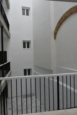 a staircase in a building with a white wall at Sweet Arco Rosa Zona Centro in Cádiz