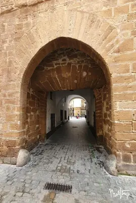 an archway in a brick wall with an alley at Sweet Arco Rosa Zona Centro in Cádiz