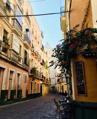 an alley with tables and chairs on a street at Sweet Arco Rosa Zona Centro in Cádiz