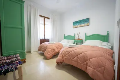 two beds in a room with green and white at LASPALOMAS18 in Sanlúcar de Barrameda