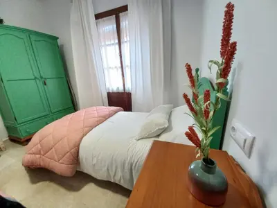 a bedroom with a green dresser and a bed with a table at LASPALOMAS18 in Sanlúcar de Barrameda