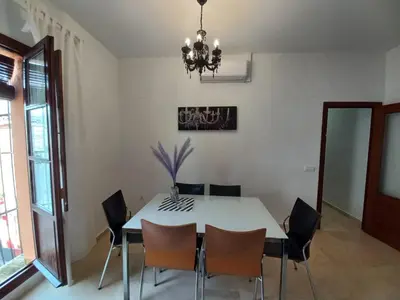 a dining room with a white table and chairs at LASPALOMAS18 in Sanlúcar de Barrameda