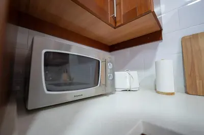 a microwave sitting on a counter in a kitchen at LASPALOMAS18 in Sanlúcar de Barrameda