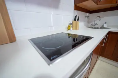 a kitchen with a sink in a white counter top at LASPALOMAS18 in Sanlúcar de Barrameda