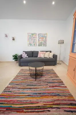 a living room with a couch and a table on a rug at LASPALOMAS18 in Sanlúcar de Barrameda