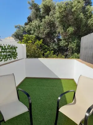 two chairs on a patio with green grass at La casa de la luz in San Fernando