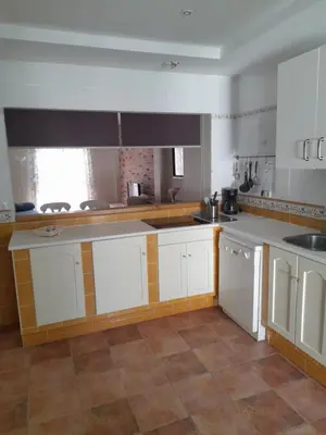 a kitchen with white cabinets and a tile floor at La casa de la luz in San Fernando