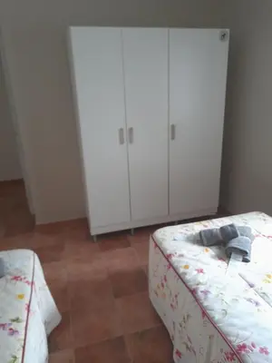 a bedroom with a bed and two white cabinets at La casa de la luz in San Fernando