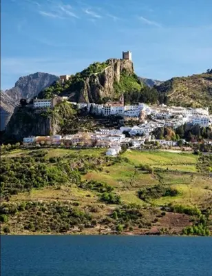 a town on top of a mountain next to the water at La casa de la luz in San Fernando