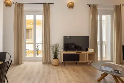 a living room with a television and a table at La Casa de Lima Little Apartments in Cádiz