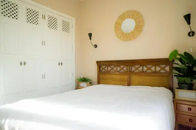 a bedroom with a bed and a mirror on the wall at Atico BLUE Beach in El Puerto de Santa María