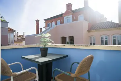 a table and chairs on a balcony with a house at Atico BLUE Beach in El Puerto de Santa María