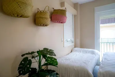 a bedroom with a bed and two baskets on the wall at Atico BLUE Beach in El Puerto de Santa María
