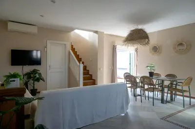 a living room with a table and a dining room at Atico BLUE Beach in El Puerto de Santa María