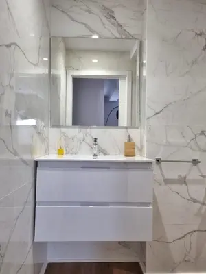 a white bathroom with a sink and a mirror at Aujada playa in Cádiz