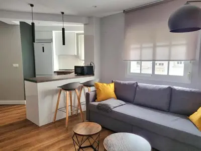 a living room with a couch and a kitchen at Aujada playa in Cádiz