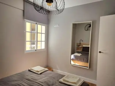 a bedroom with a bed and a mirror at Aujada playa in Cádiz