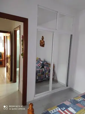 a bedroom with a glass closet with a bed in it at ALQUILER CHIPIONA in Chipiona