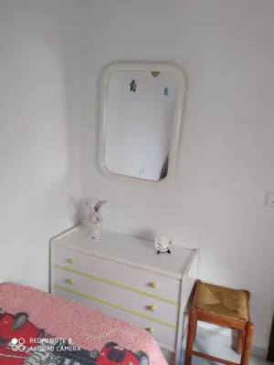 a bedroom with a dresser and a mirror on the wall at ALQUILER CHIPIONA in Chipiona