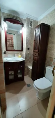 a bathroom with a toilet and a sink and a mirror at Apartamento a pie de playa La Barrosa in Chiclana de la Frontera