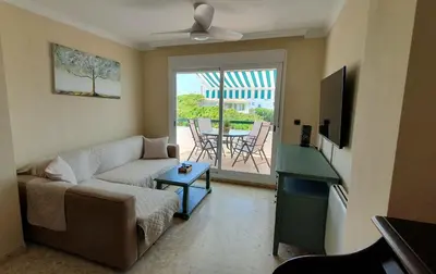 a living room with a couch and a table at Apartamento a pie de playa La Barrosa in Chiclana de la Frontera